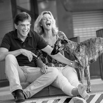 lachende Personen mit Hund auf Industrieboden